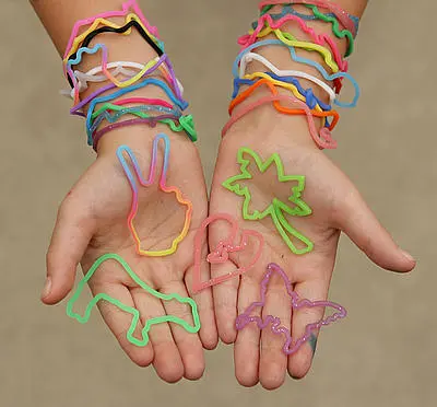 Open hands holding a variety of colorful silly bandz